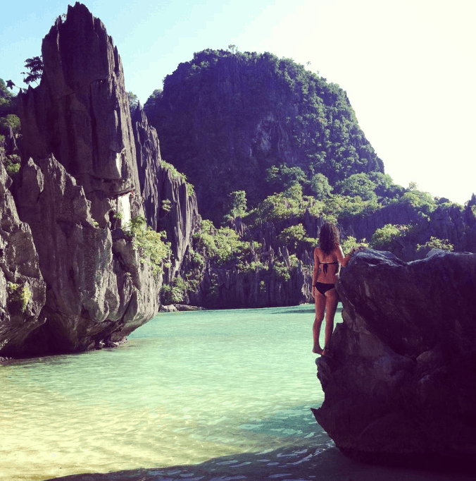 Nina in El Nido, Philippines while backpacking Southeast Asia climbing rocks on the beach.