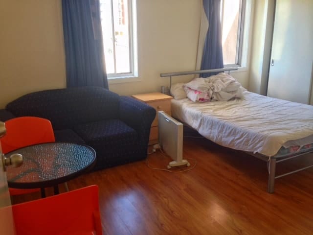 My studio apartment, a small room with couch and bed, in Melbourne Australia
