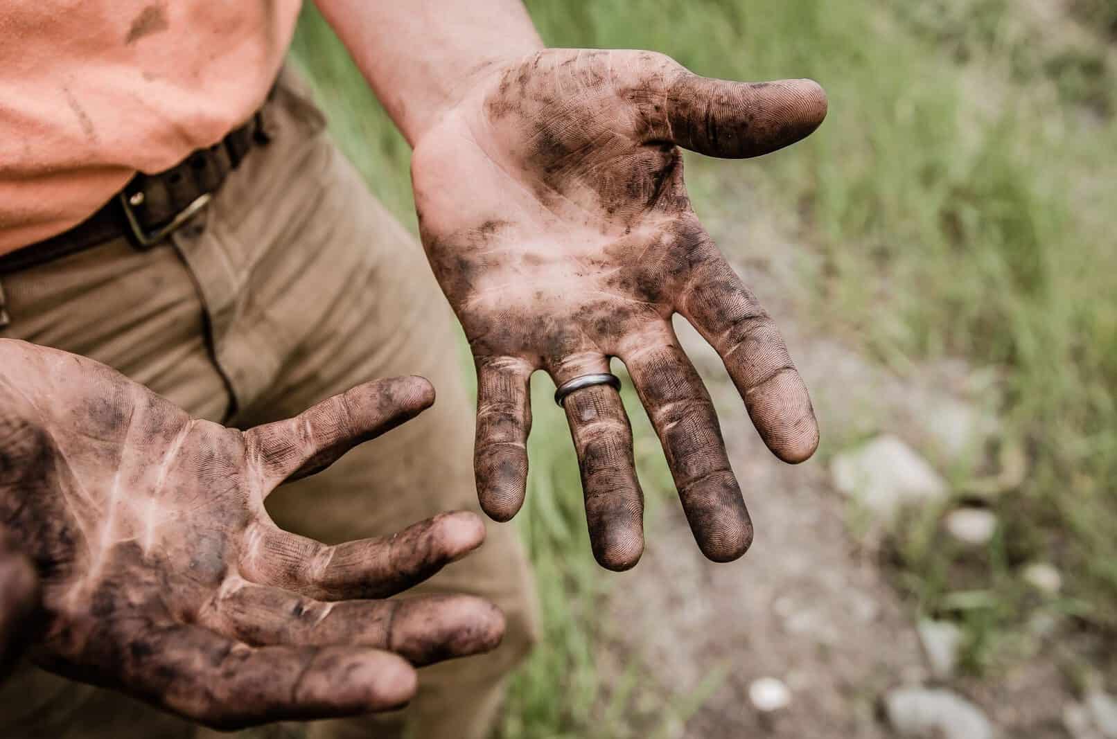 A person working in Australia with dirty hands.