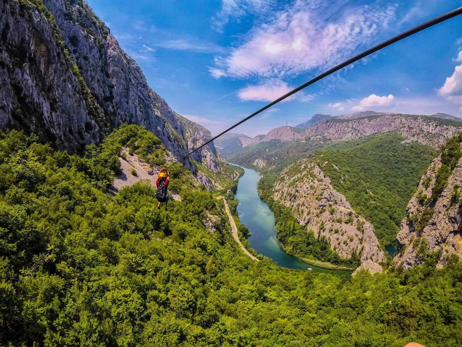Nina zip-lining over the Centina River hundreds of feet in the air in the Croatian mountains of Omis.