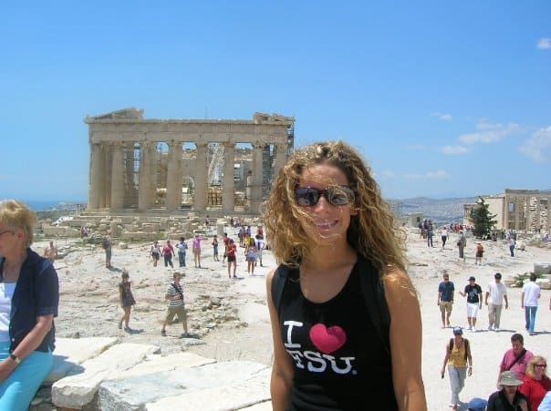 A younger Nina standing in front of a historic monument in Athens, Greece.