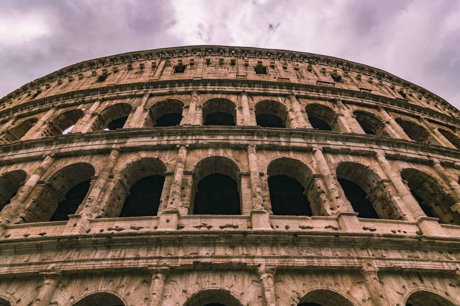 A POV looking up at the huge colosseum in Rome, Italy.
