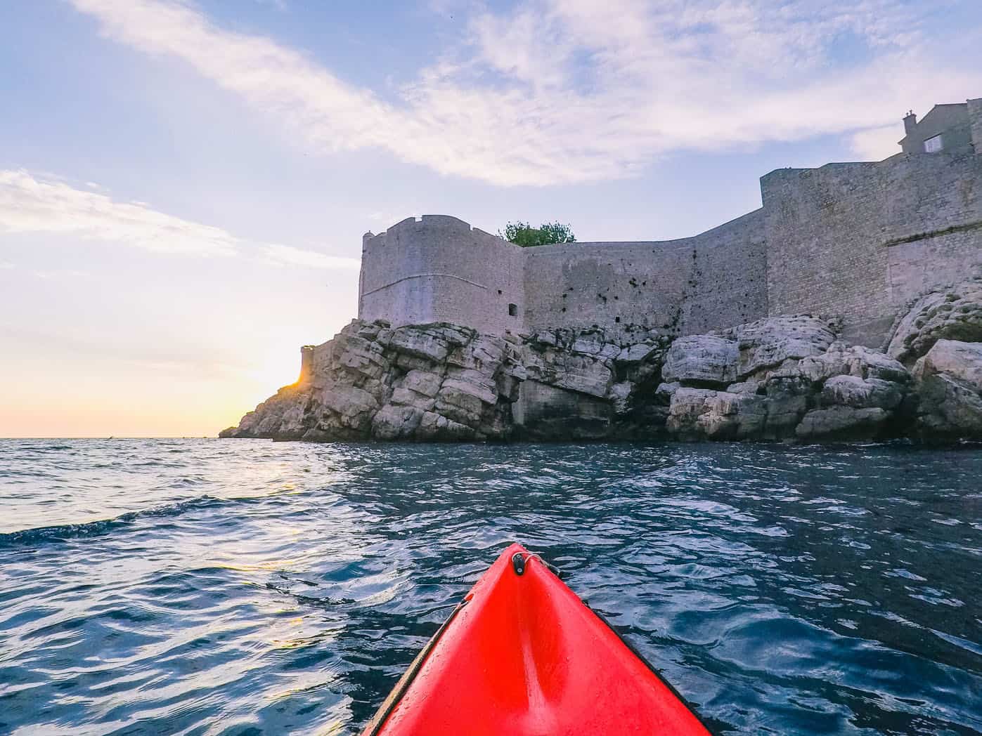 A POV of Dubrovnik's castle walls from a kayak on the ocean in Croatia.