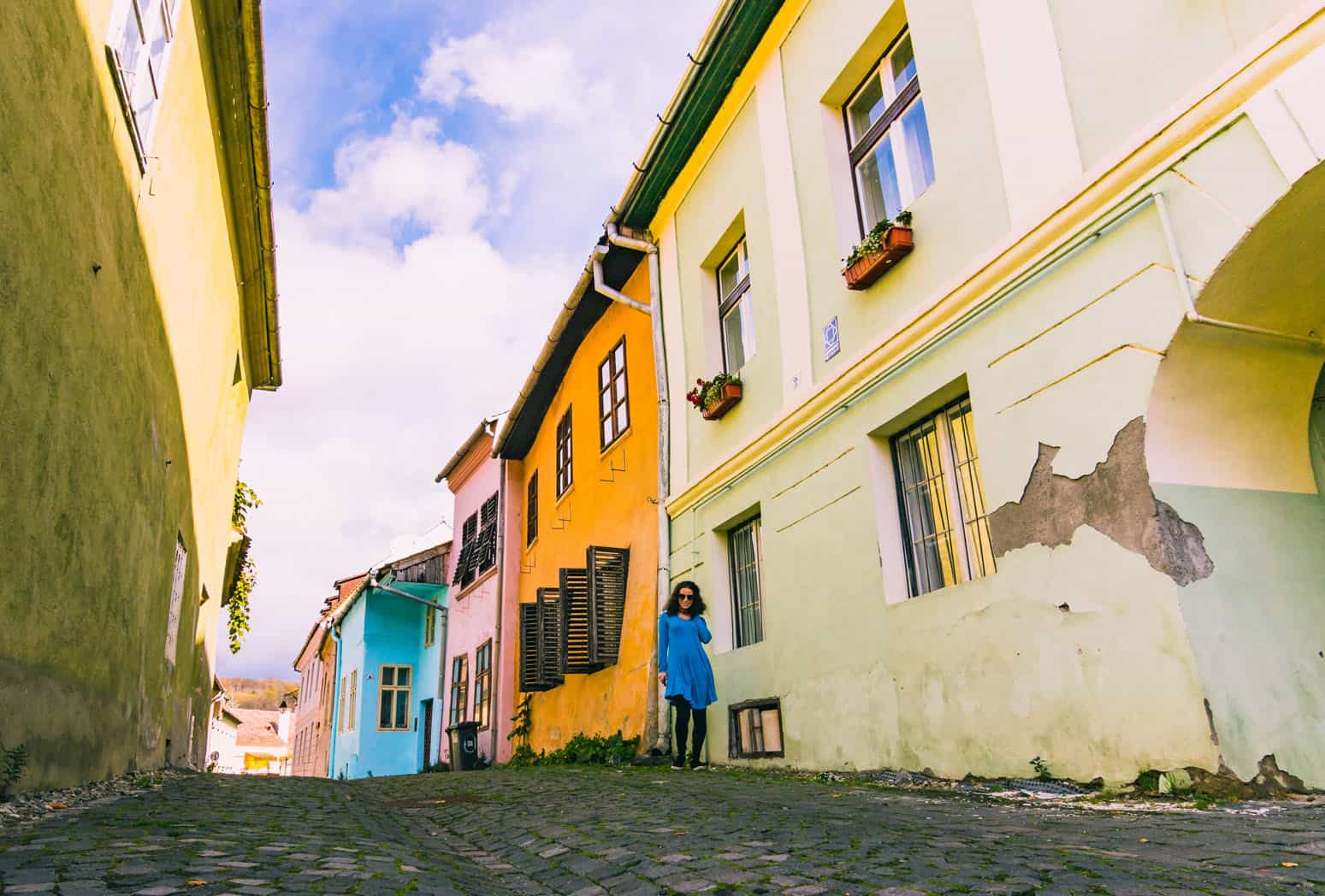 Nina walking along a typical and colorful street in Transylvania, Romania.