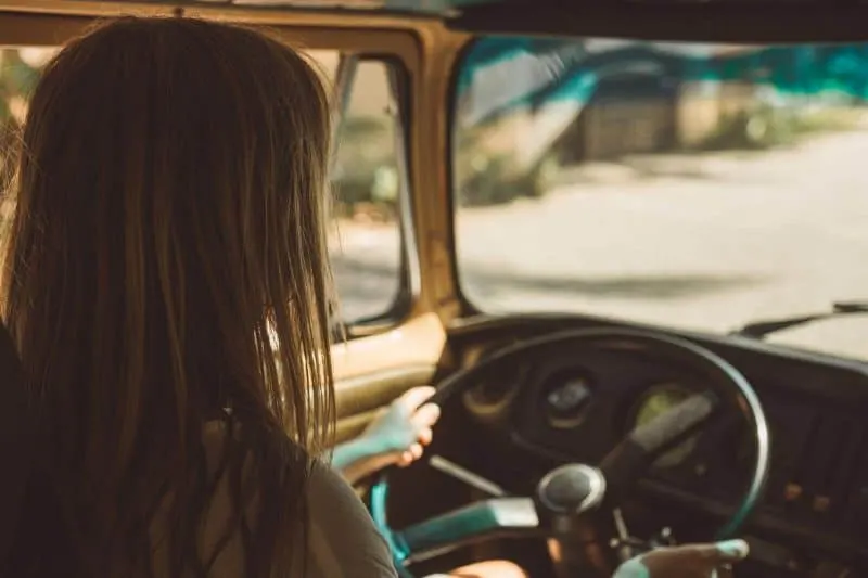 Girl behind the wheel on a road tr