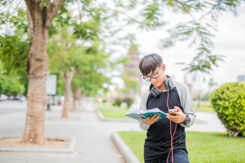 student reading a book outside