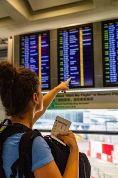 Me point at flight schedule in airport before moving out of the USA