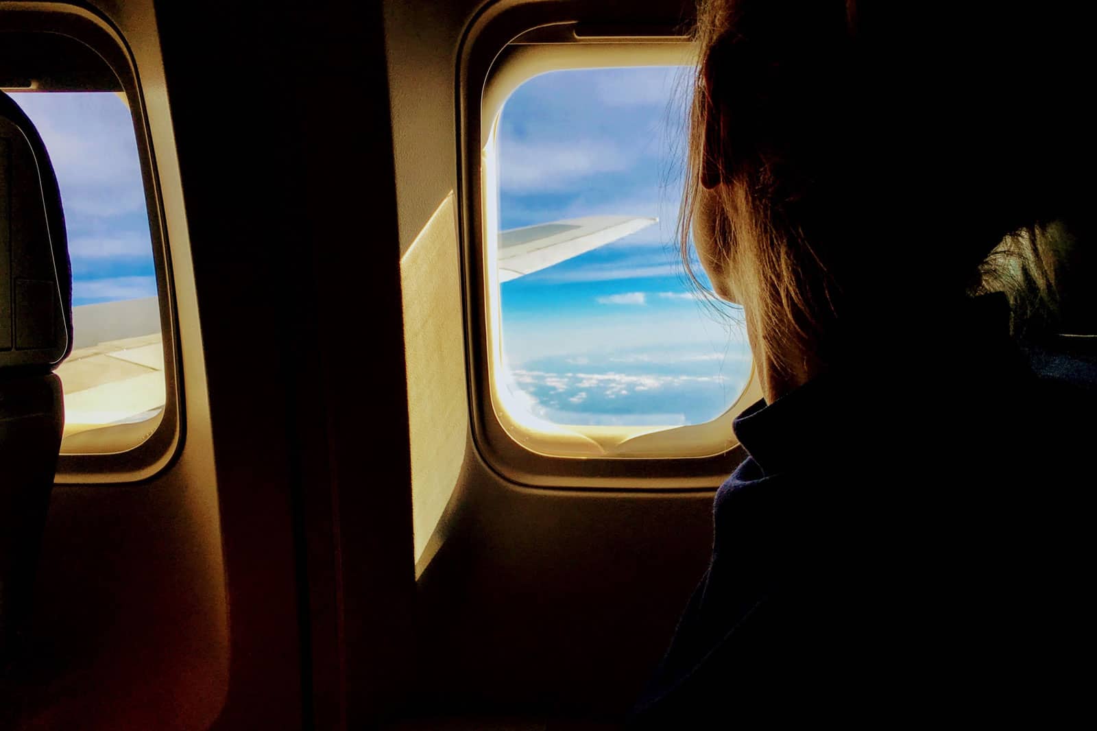 person riding on a plane looking through the window