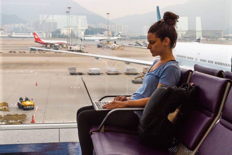 woman working on laptop as a digital nomad in an airport