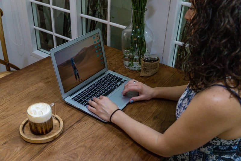 woman working on laptop as a digital nomad in a cafe