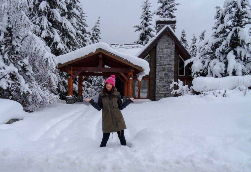 Woman near snowy house 