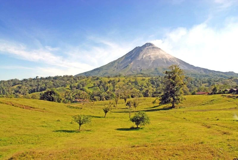Volcano with grassy plains with trees in foreground in Costa Rica