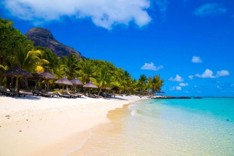 Tropical beach with beach huts lining it in Mauritius