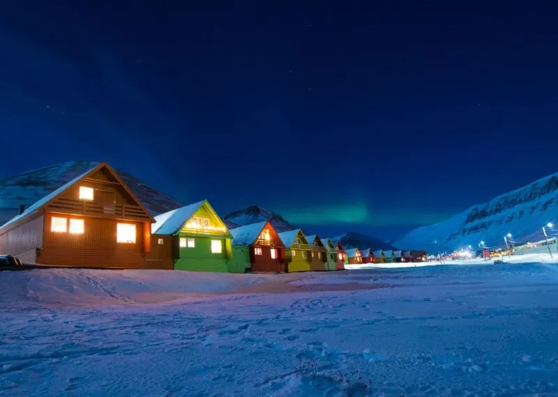 Huts lit up at night in the snow in Svalbard in Norway