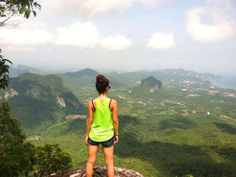 Woman looking out over rolling hills in Krabi, Thailand