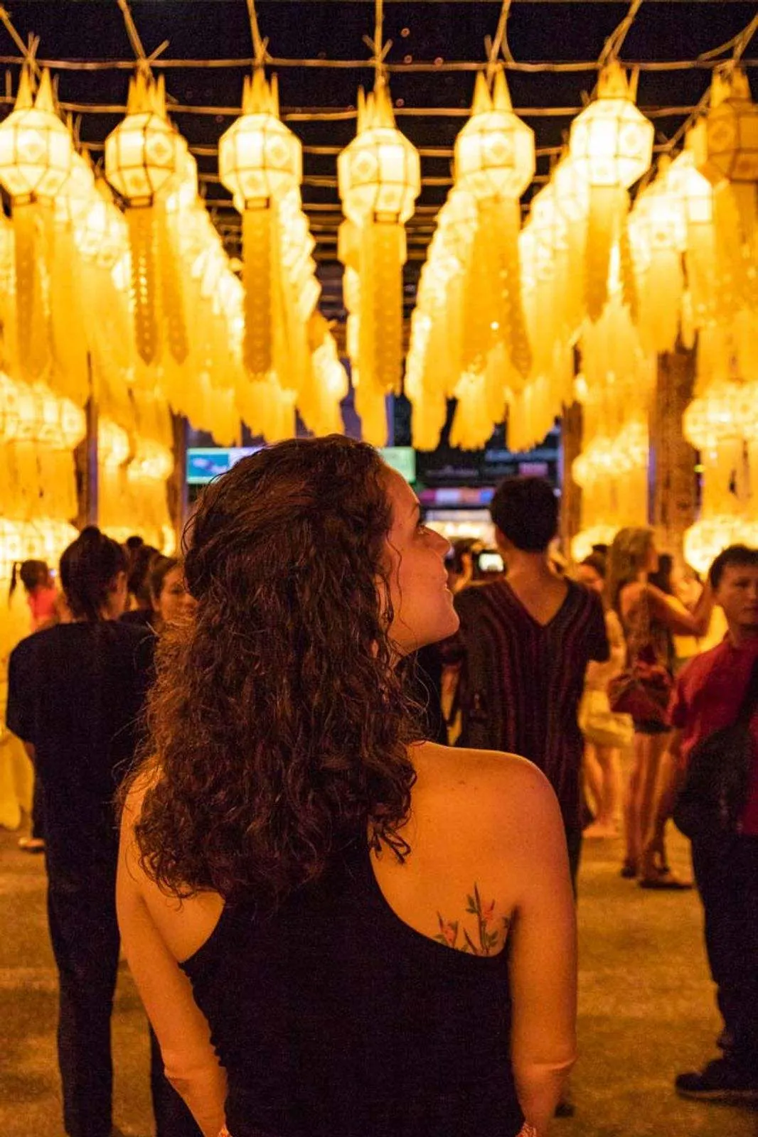 Woman looking up at lanterns at Loi Krathong festival while living in Thailand