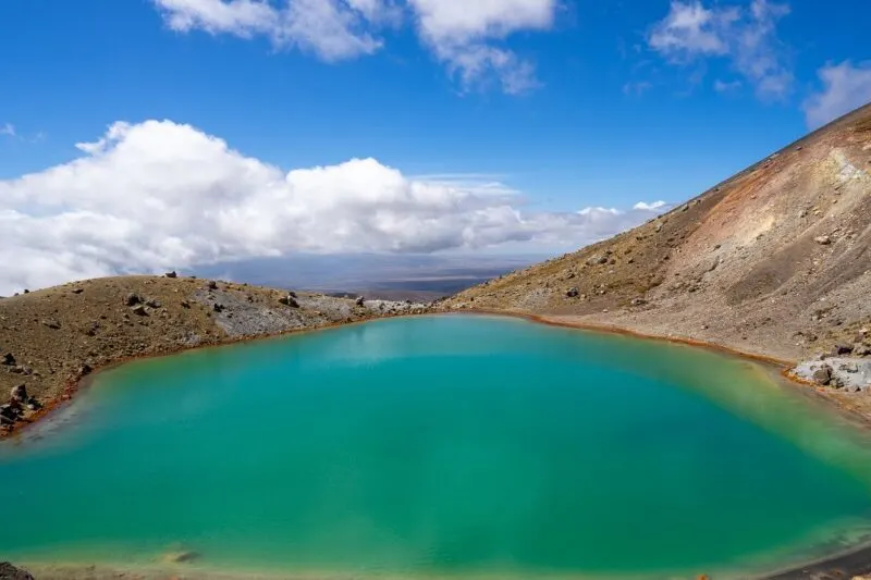 Blue Lake surrounded by arid hills on the Tongariro Hike