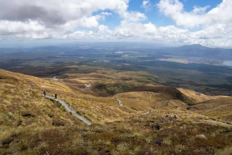Views over Tongariro National Park with people hiking on trail in distance
