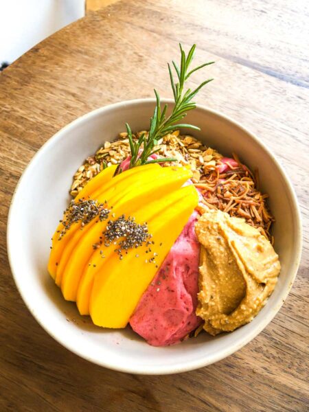 Smoothie bowl with fresh mango on top on table at Anchor - one of the best Sayulita Restaurants