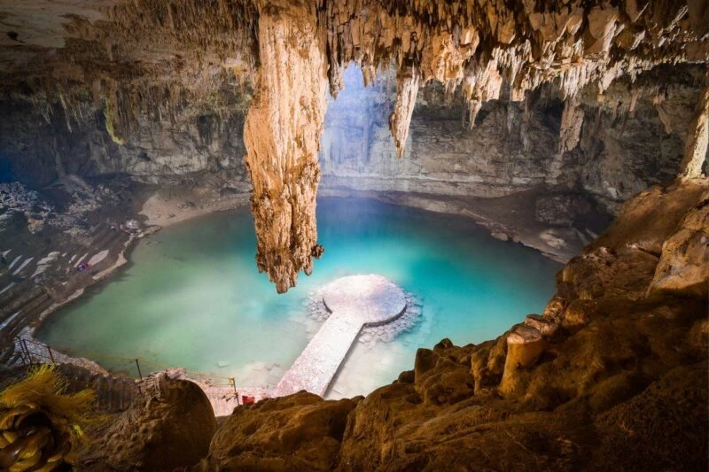 An underground cave cenote with stalactites and platform in water in Yucatan, Mexico
