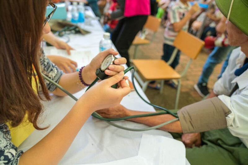 Doctor or Nurse taking someone's blood pressure - work as a doctor abroad