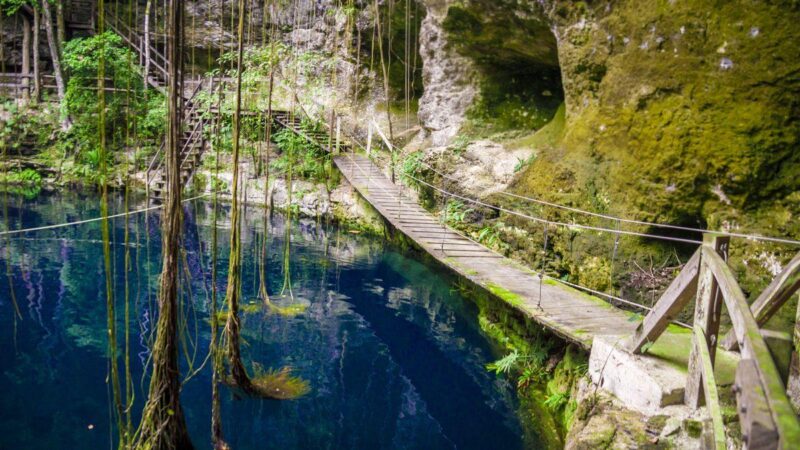 Ek Balam ruin with bridge crossing water and vines hanging down - part of your Yucatan Itinerary