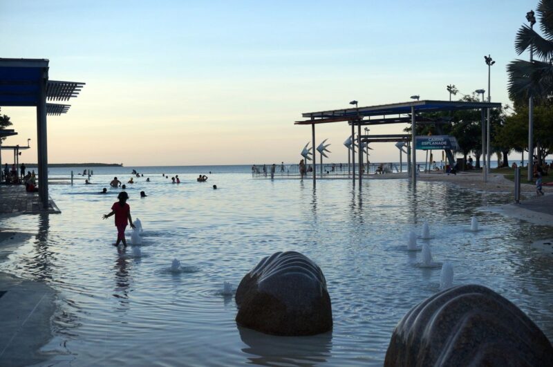 Person standing in water at Esplanade Lagoon at sunset - one of the best things to do in Cairns