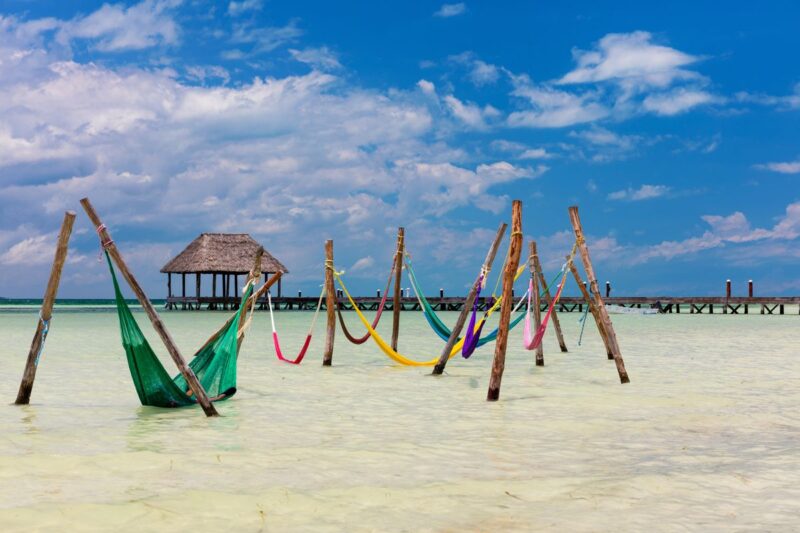 Hammocks over shallow ocean on Isla Holbox, a great addition to your Yucatan Itinerary