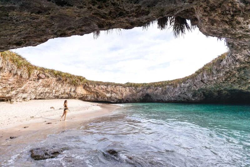 Person walking on beach in an open crater at Marieta Islands, one of the best Sayulita Beaches