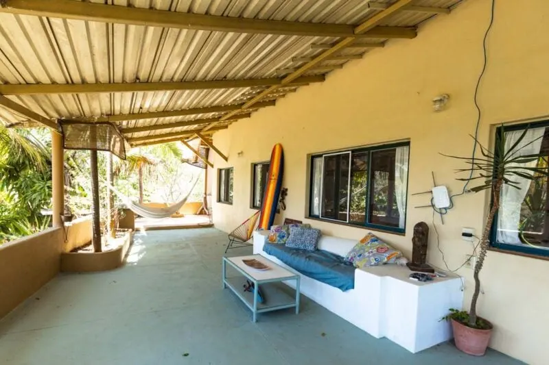 Covered terrace with couch and coffee table in Sayulita, Mexico is the perfect spot to post up when planning a trip. 