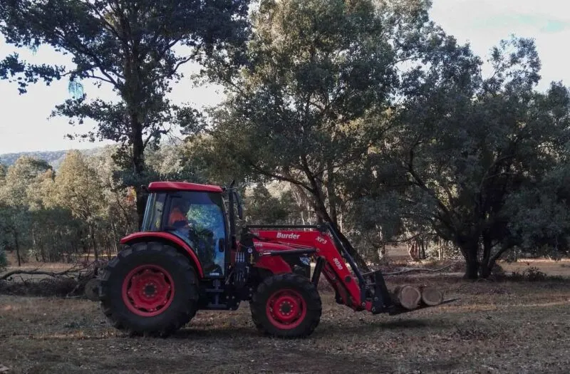 Red tractor with trees in background used for farm work in Australia
