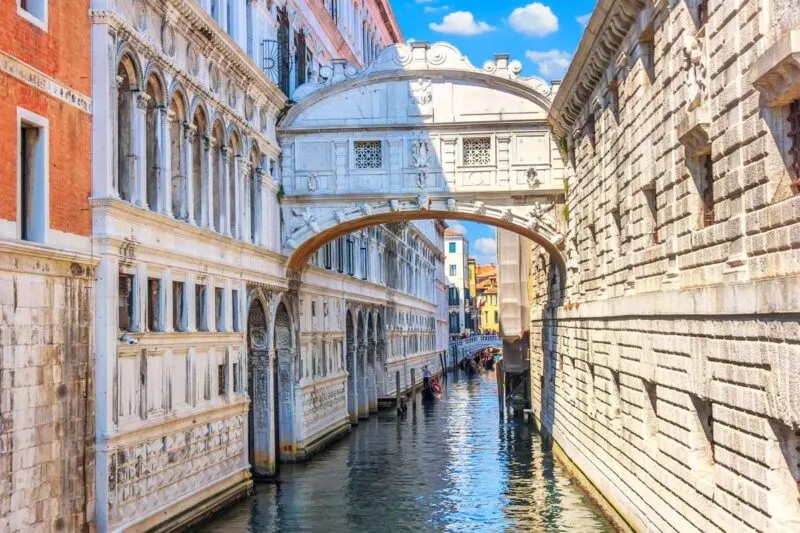 Bridge of Sighs arching over a narrow canal with buildings on each side - add this iconic bridge to your Venice Itinerary
