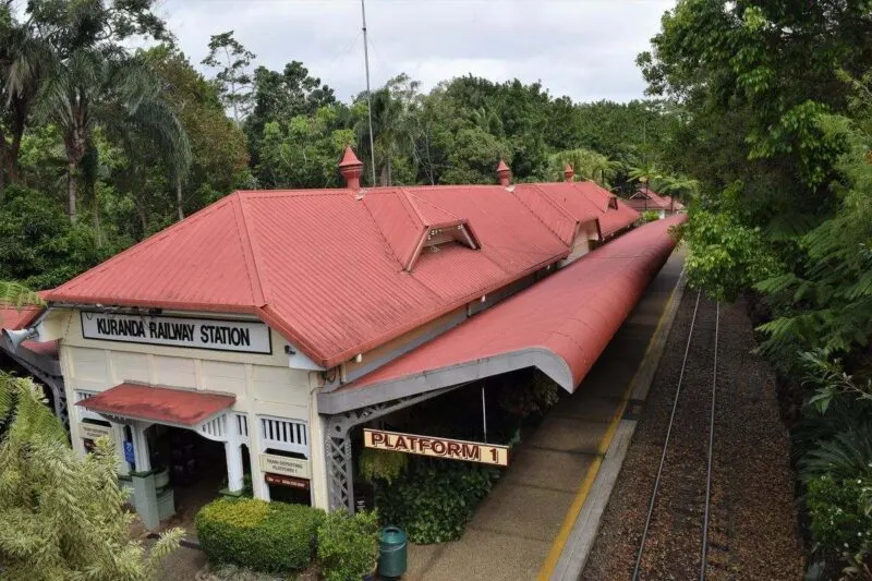 View over Kuranda train station with train tracks beside it and trees on either side - visiting Kuranda is one of the best things to do in Queensland