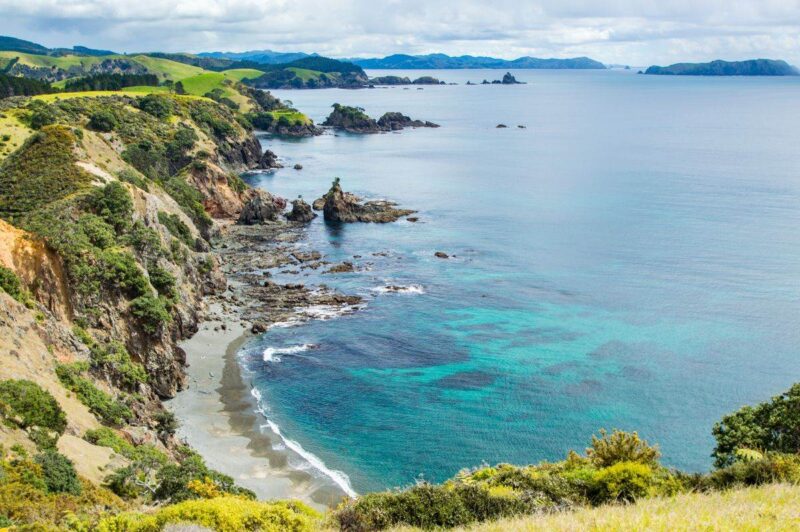 Aerial view of beach, ocean and headland at Matauri Bay - one of the best things to do in Northland