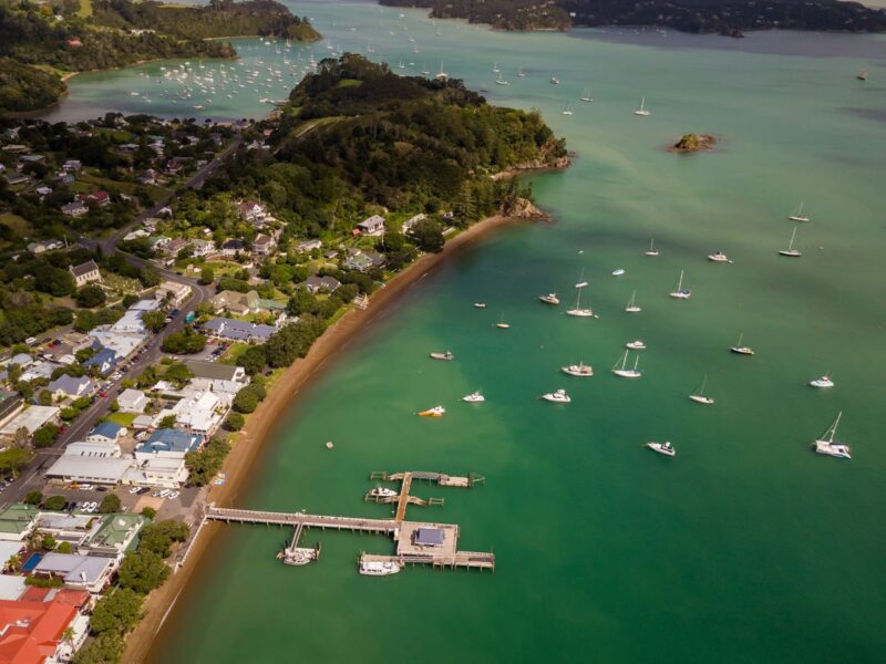 Aerial view over ocean, wharf, and buildings in Russell - a visit here is one of the best things to do in Northland