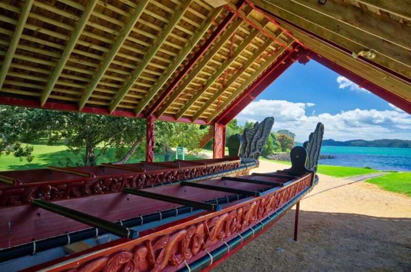 Waka canoe under shelter with ocean in background at Waitangi Treaty Grounds in Northland