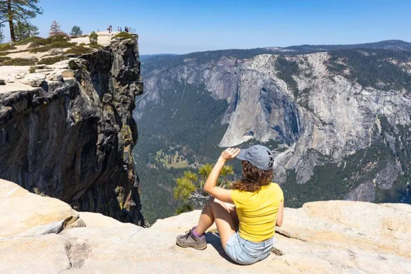 Woman sitting on cliff at Taft Point in Yosemite National Park