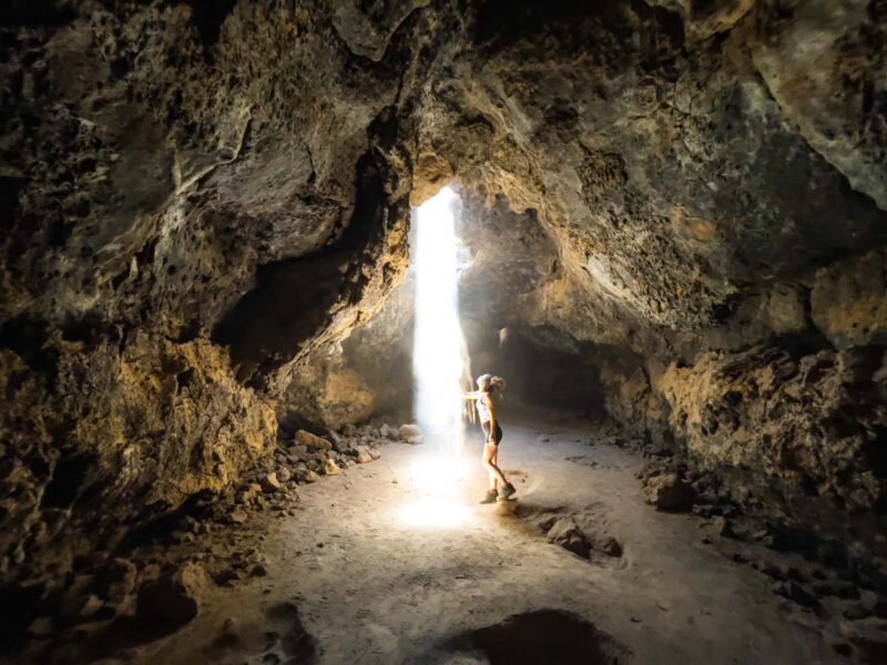 Woman under a lava tube in a cave in the Mojave Desert
