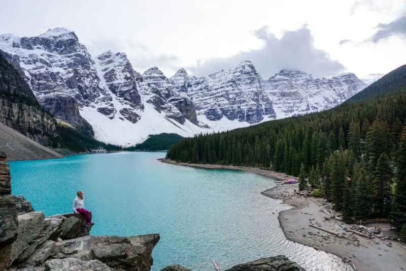 Woman on rocks overlooking Moraine Lake in Banff National Park