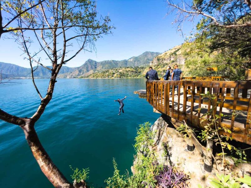 Man jumping off platform at Cerro Tzankujil on Lake Atitlan, Guatemala