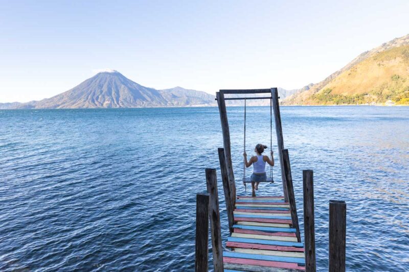 Woman on swing at jetty on Lake Atitlan in Guatemala