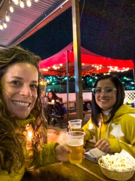 Two women drinking beer and eating popcorn in Xela Guatemala