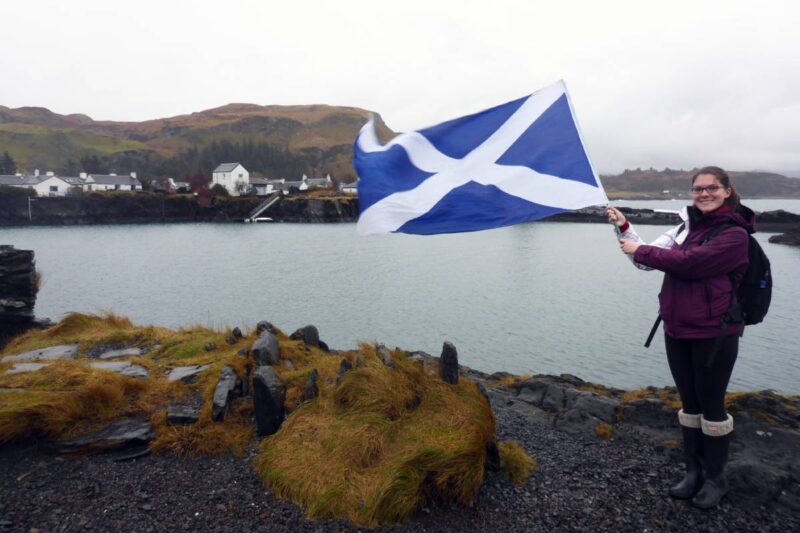 Woman holding Scottish flag working in the UK as a foreigner
