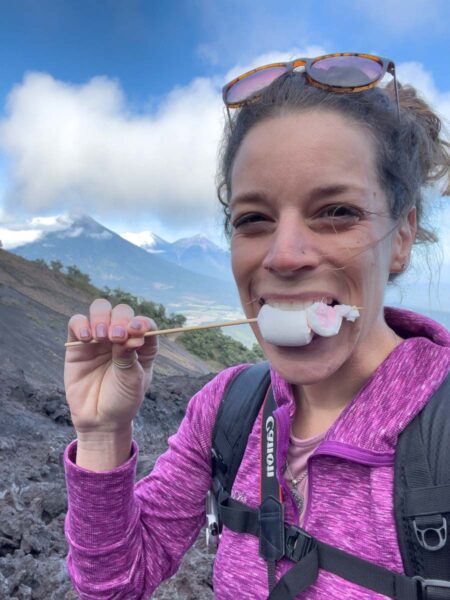 Woman eating marshmallows on Pacaya volcano is one of the things to do in Antigua Guatemala