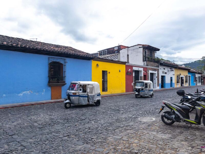 Tuk tuks parked outside colorful buildings in Antigua, Guatemala