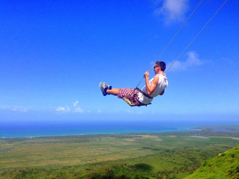 Man on swing at Montana Redonda best place to visit in Dominican Republic