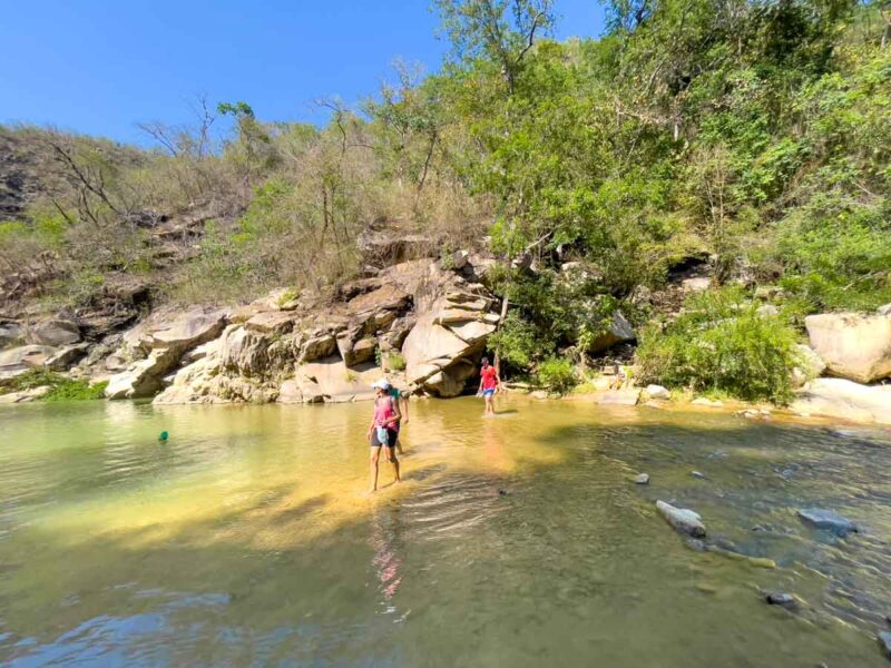 Hikers crossing the river at Cascada La Reforma