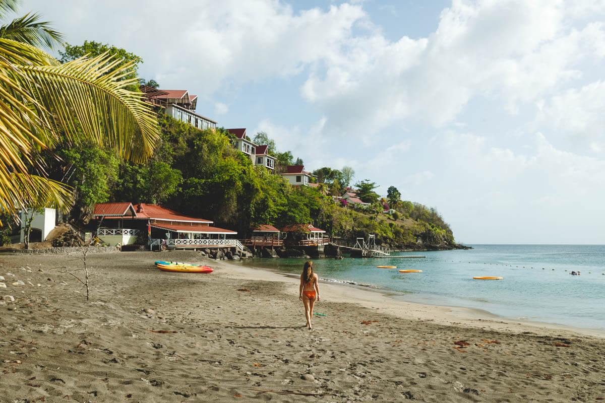 Woman on Anse Cochon Beach in St Lucia with palms to the left. 