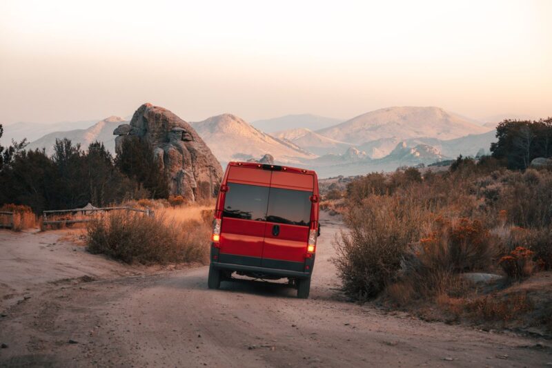 Red RV campervan on desert road planning a road trip