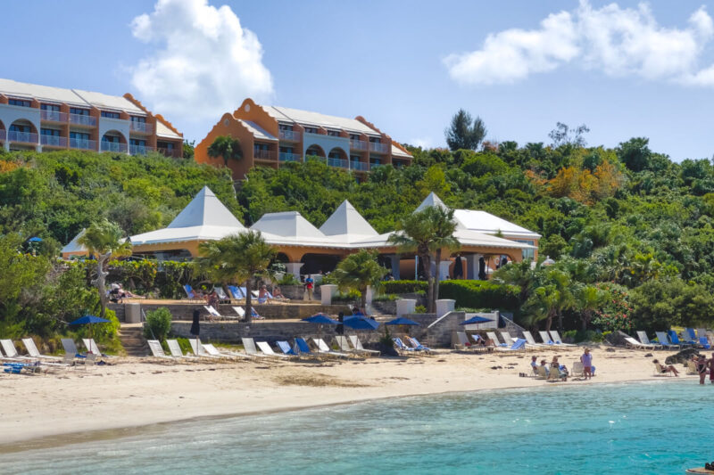 Grotto Bay Beach Resort in Bermuda with canopies lining the beach and people swimming